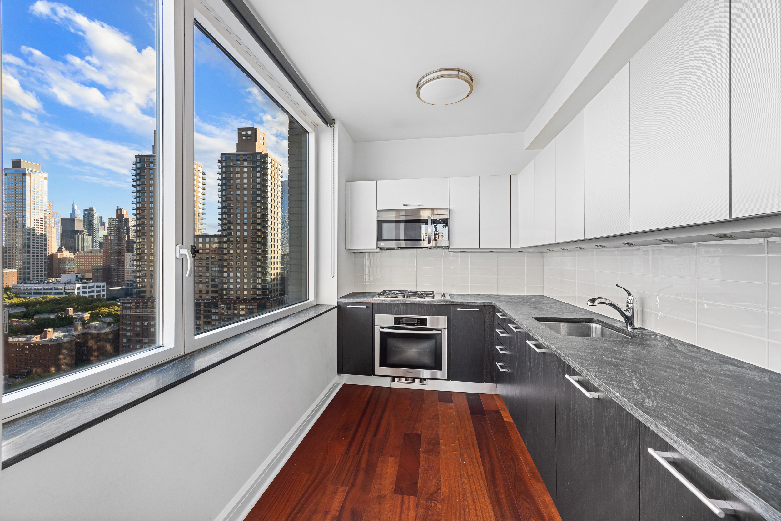 100 Riverside Boulevard, Unit 21A Manhattan, NY 10069 - Photo 8 of 22 a kitchen with granite countertop a stove top oven and sink