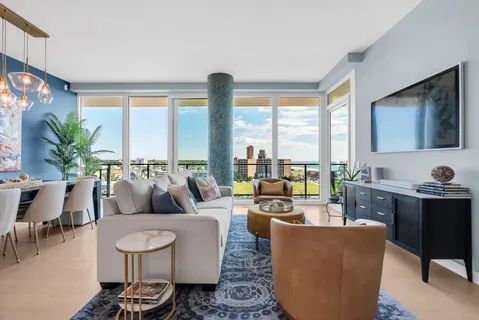 a living room with furniture large window and a flat screen tv