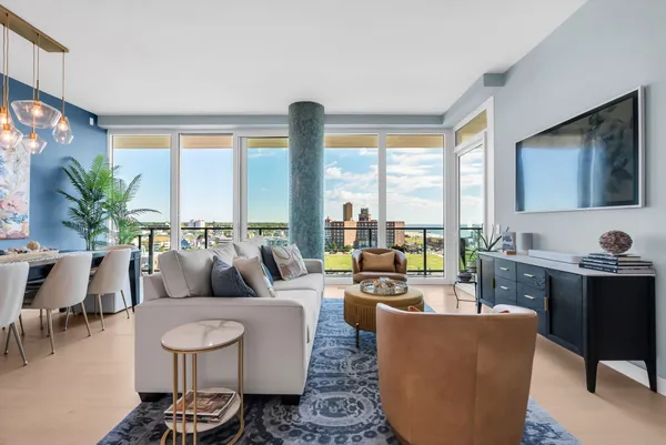 a living room with furniture large window and a flat screen tv