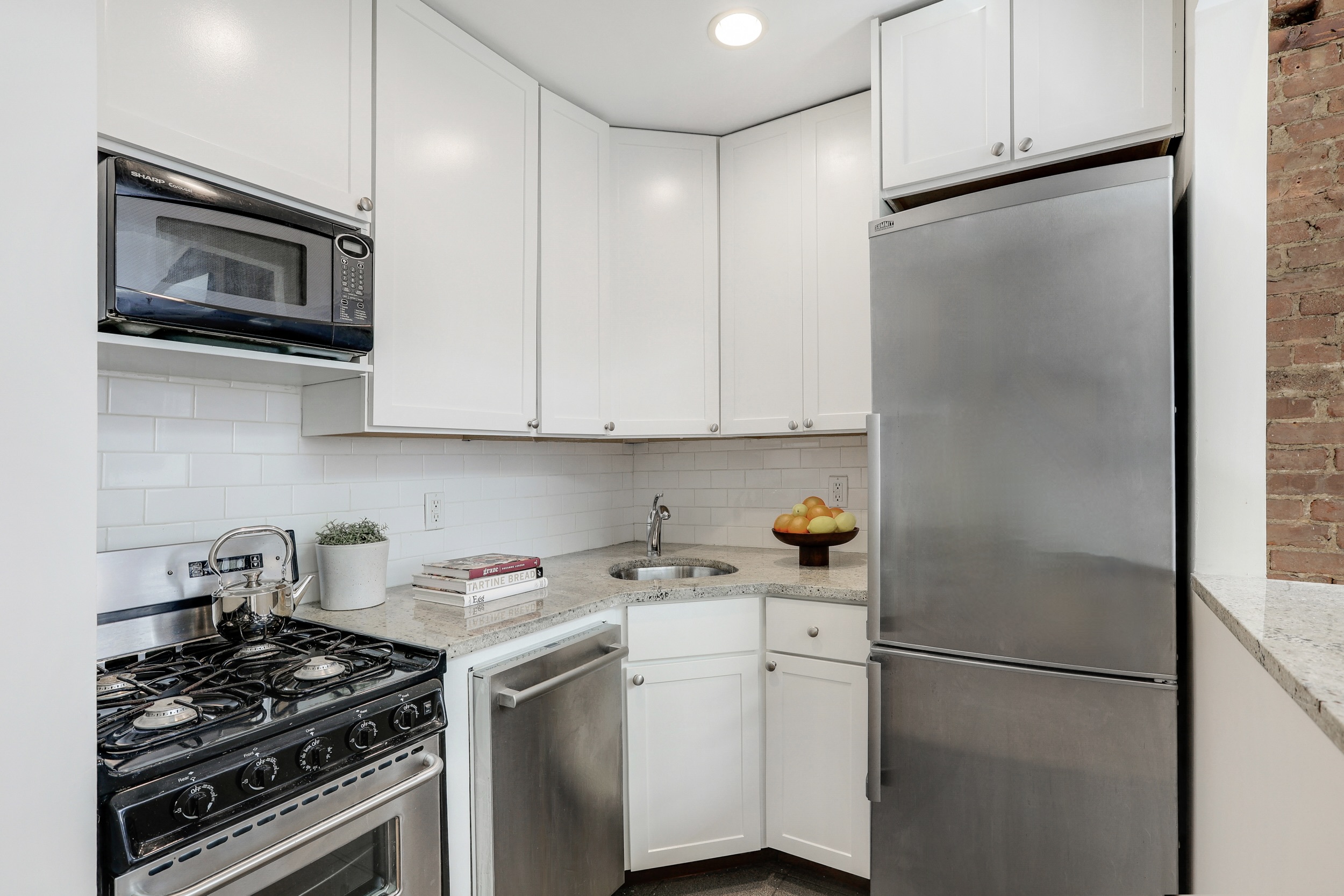 304 West 88th Street, Unit 4B Manhattan, NY 10024 - Photo 5 of 8 a kitchen with a refrigerator stove and white cabinets
