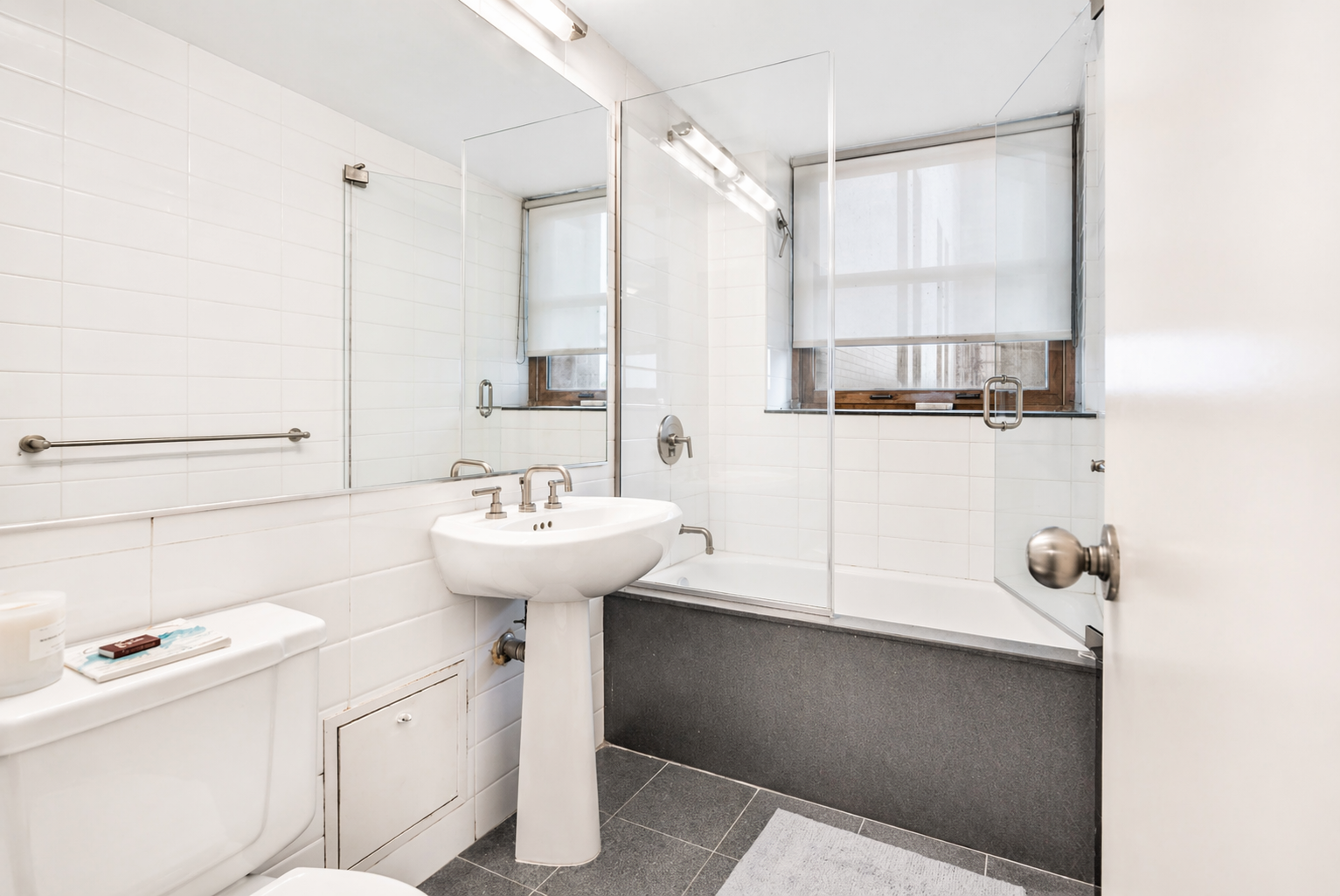 305 2nd Avenue, Unit 518 Manhattan, NY 10003 - Photo 11 of 19 a bathroom with a sink a toilet and mirror