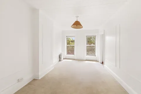 an empty room with windows and fan