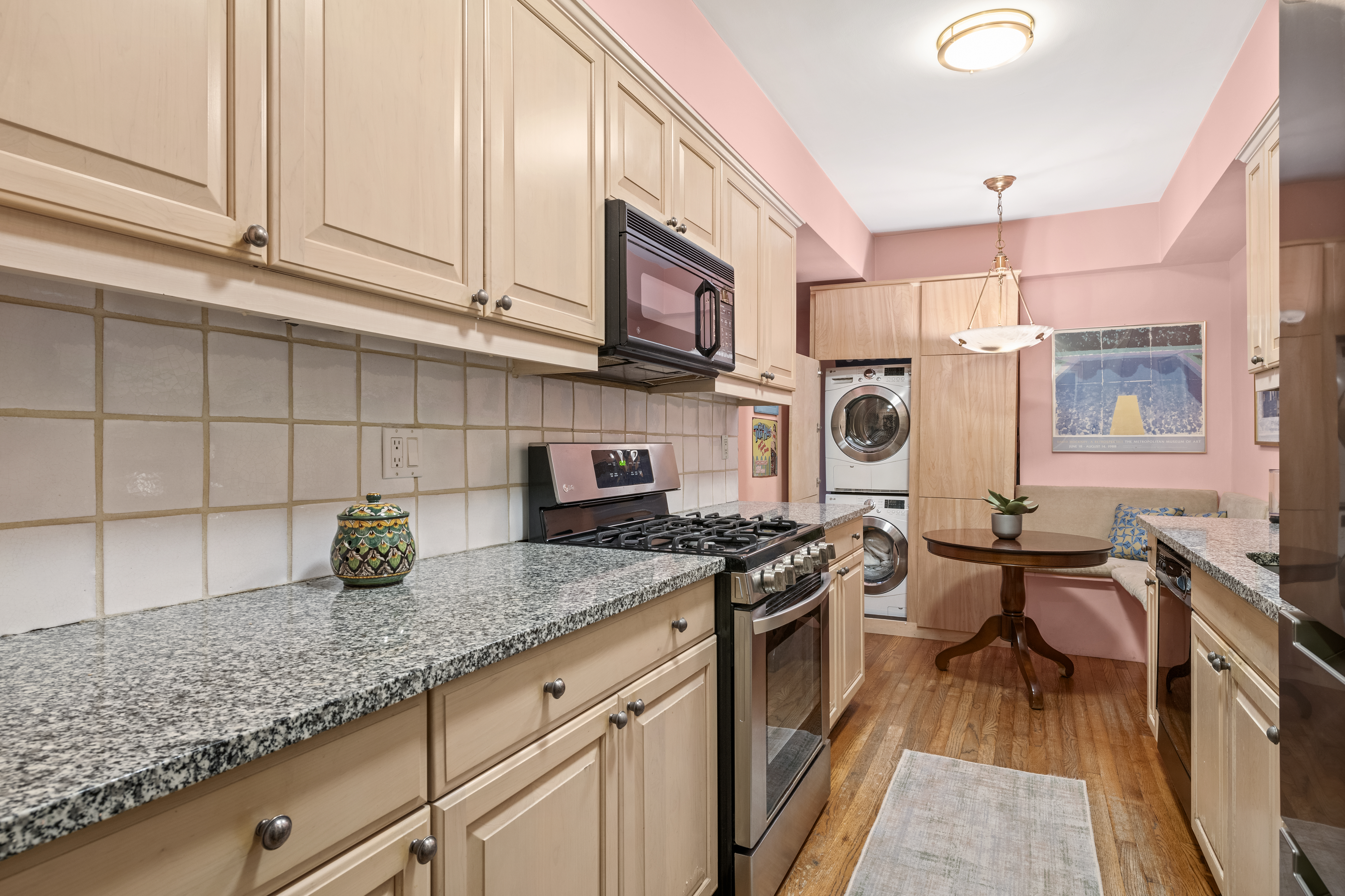 205 East 78th Street, Unit 12J Manhattan, NY 10075 - Photo 4 of 9 a kitchen with stainless steel appliances granite countertop a stove a sink and a microwave