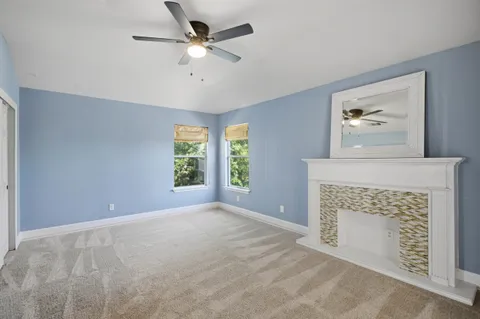 an empty room with windows and fireplace