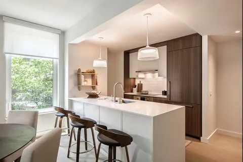 a kitchen with a dining table chairs and white cabinets