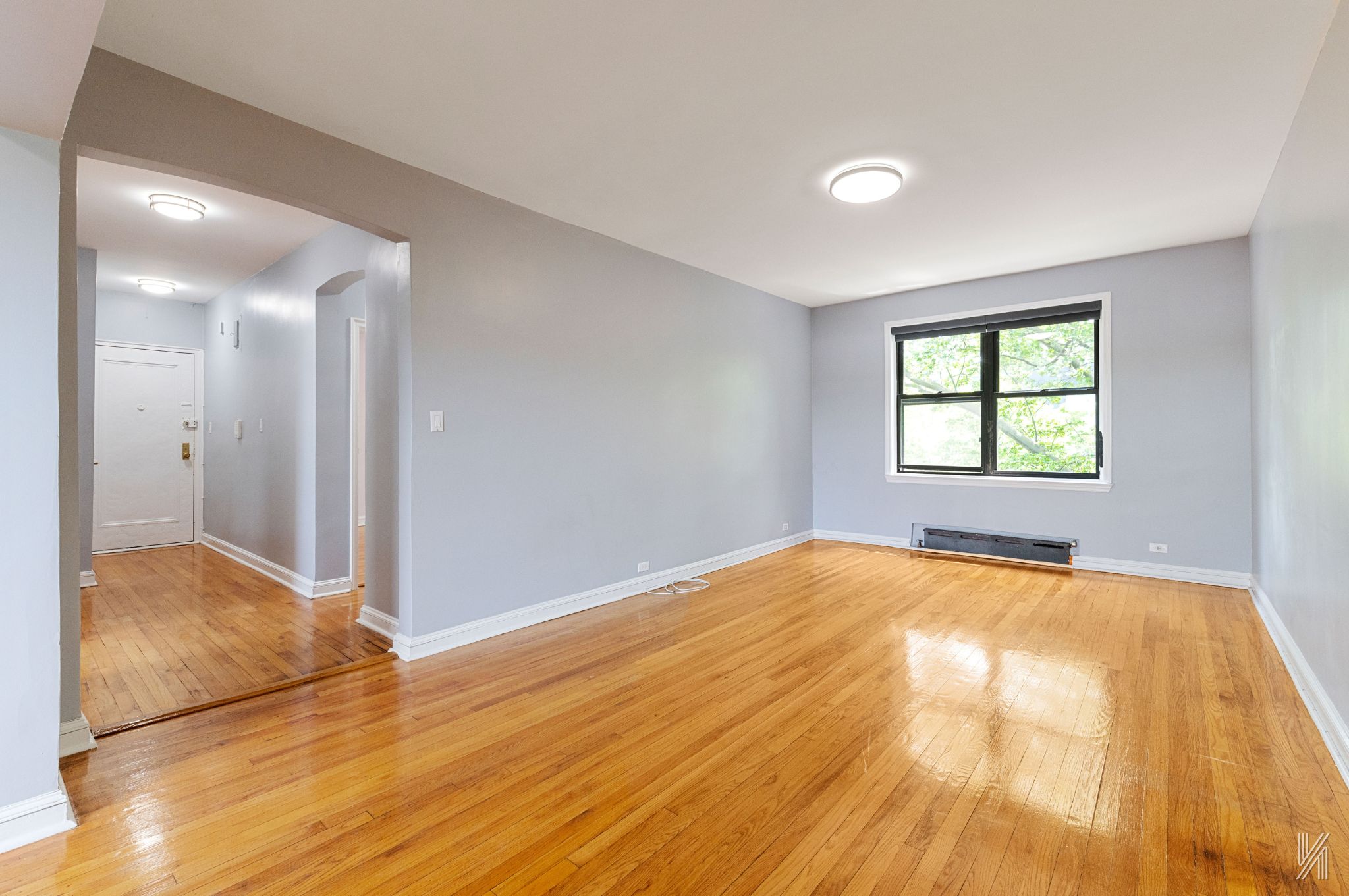 22-20 76th Street, Unit C3 Queens, NY 11370 - Photo 6 of 20 a view of empty room with wooden floor and fan