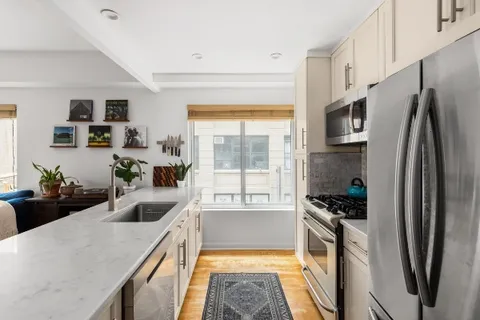 a kitchen with stainless steel appliances a refrigerator sink and stove
