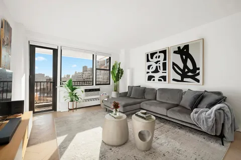 a living room with furniture and a floor to ceiling window