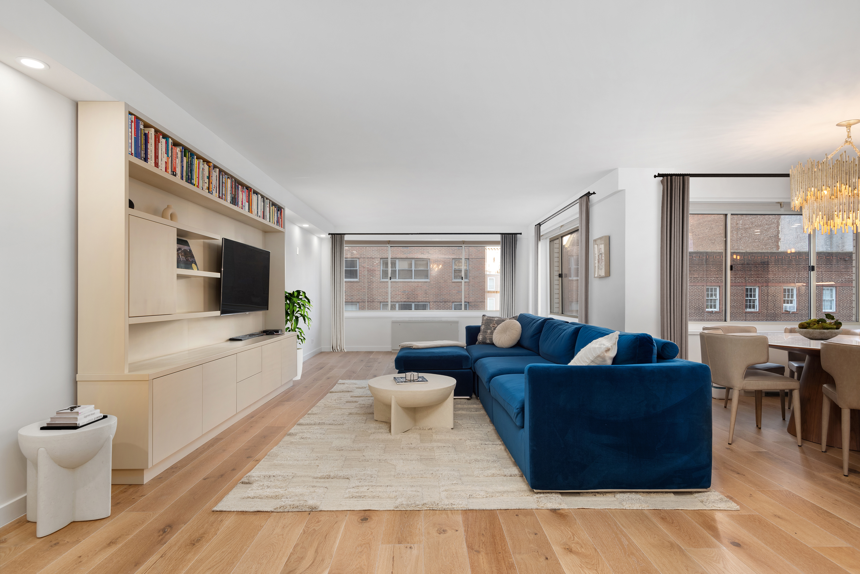 30 East 65th Street, Unit 6B Manhattan, NY 10065 - Photo 1 of 14 a living room with furniture and a flat screen tv
