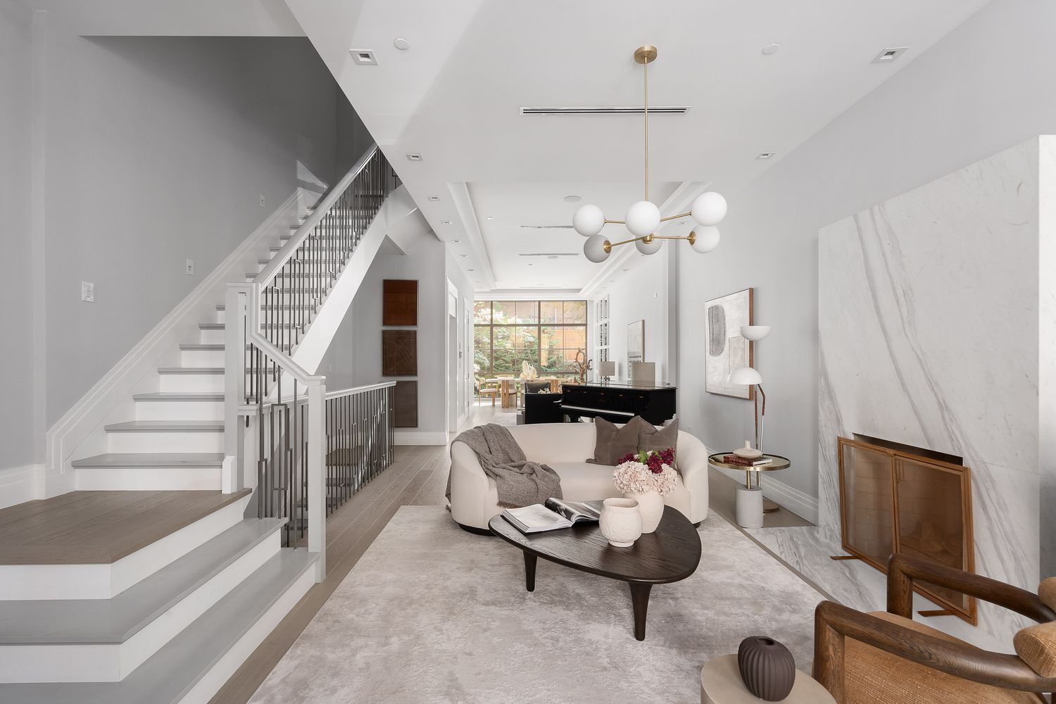 520 East 89th Street Manhattan, NY 10128 - Photo 33 of 40 a living room with furniture a fireplace and a chandelier