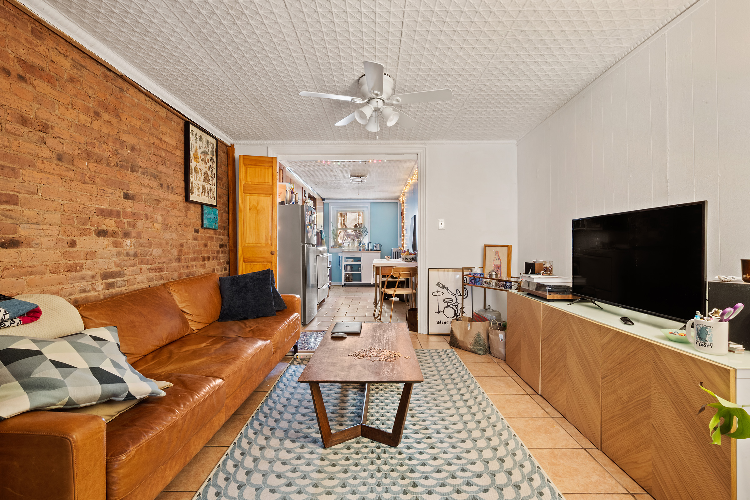 167 St Nicholas Avenue Brooklyn, NY 11237 - Photo 2 of 6 a living room with furniture and a flat screen tv