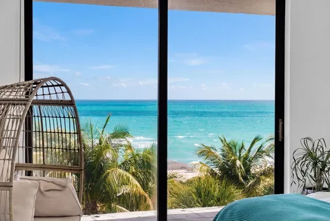 a view of a porch with a floor to ceiling window next to a yard