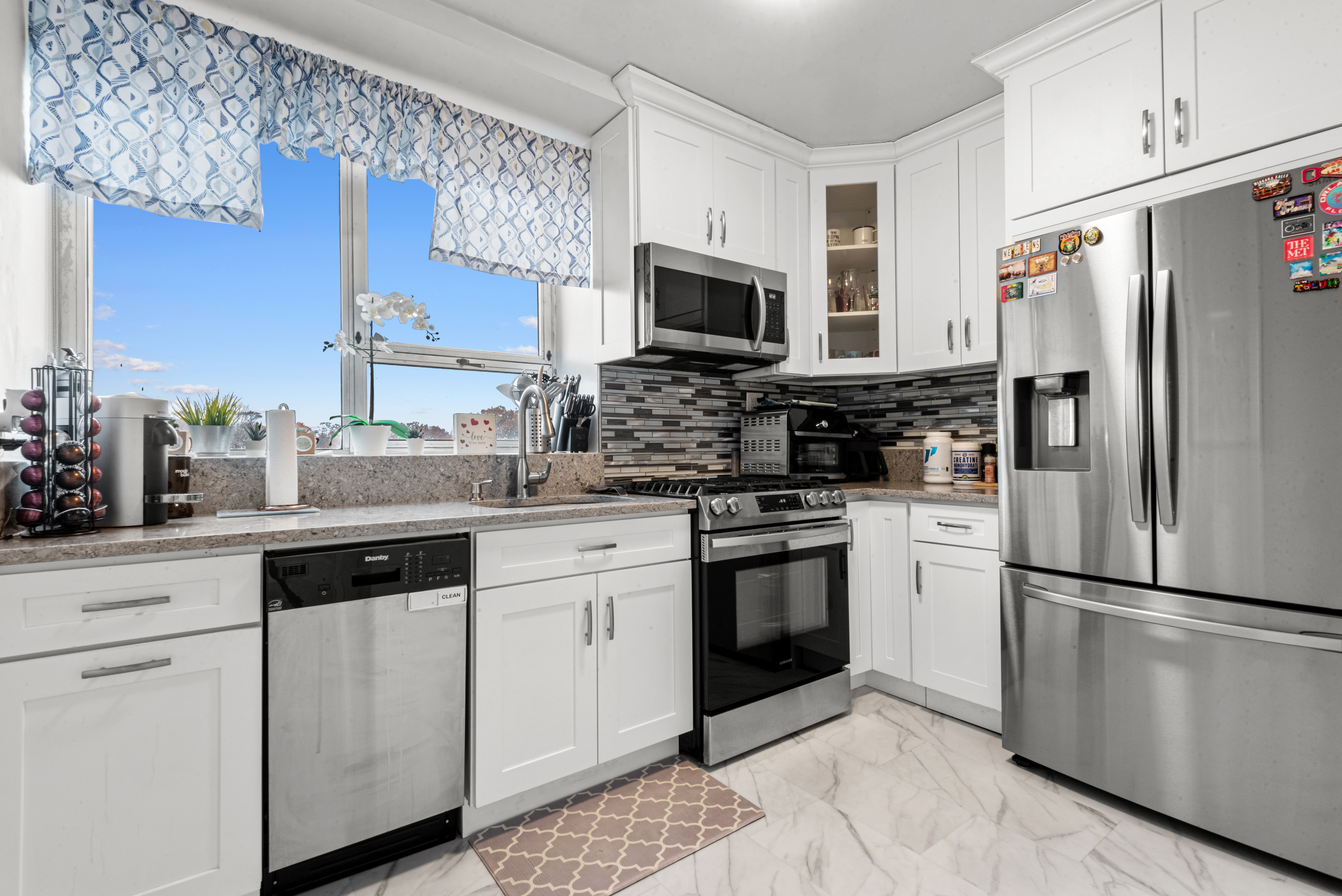 4 Horizon Road, Unit 1013 Fort Lee, NJ 07024 - Photo 10 of 18 a kitchen with stainless steel appliances granite countertop a refrigerator stove a sink and a microwave