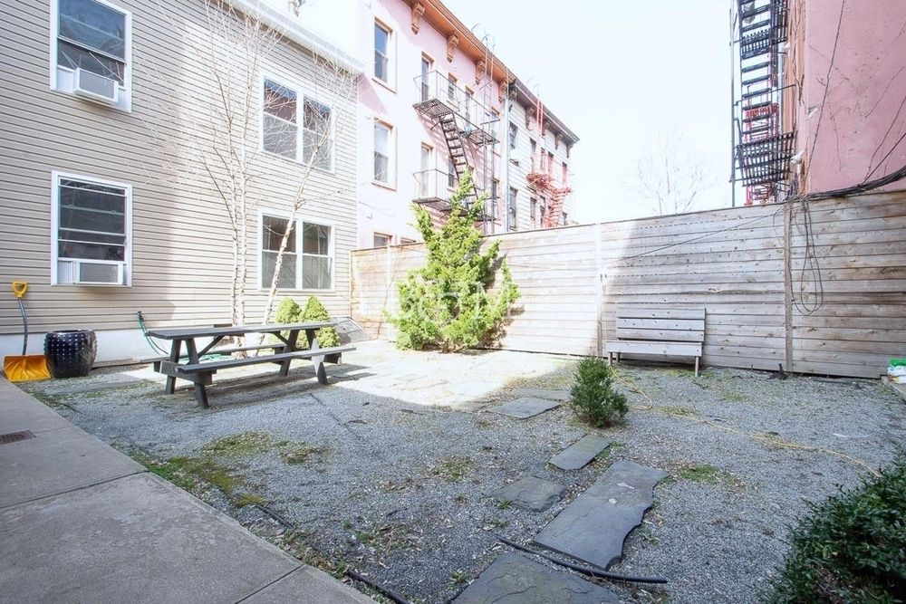 251 Powers Street Brooklyn, NY 11211 - Photo 11 of 11 a view of a backyard with chairs and a potted plant