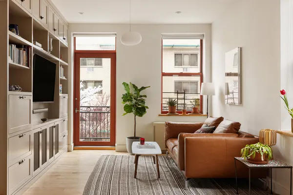 a living room with furniture a flat screen tv and a window