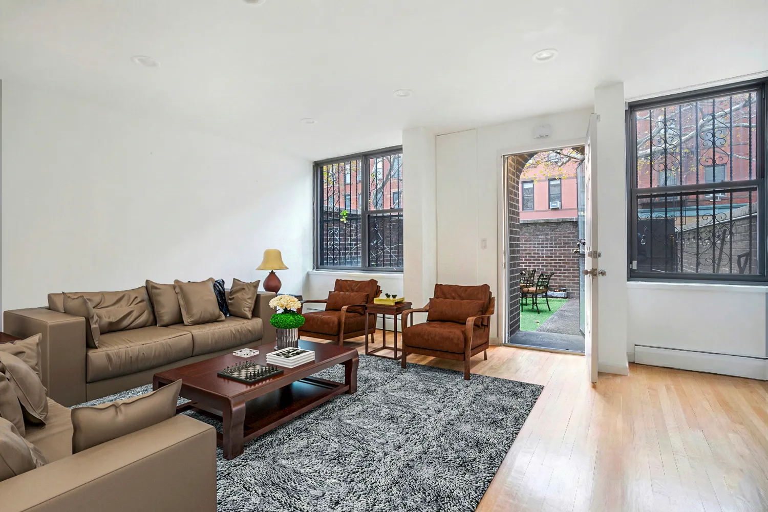 a living room with furniture floor to ceiling window and wooden floor