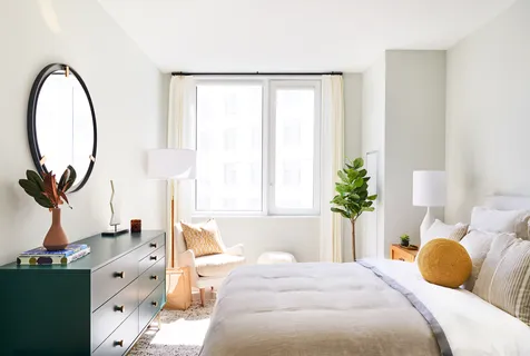 a bedroom with a bed and a large window