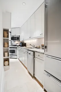 a kitchen with granite countertop white cabinets and stainless steel appliances