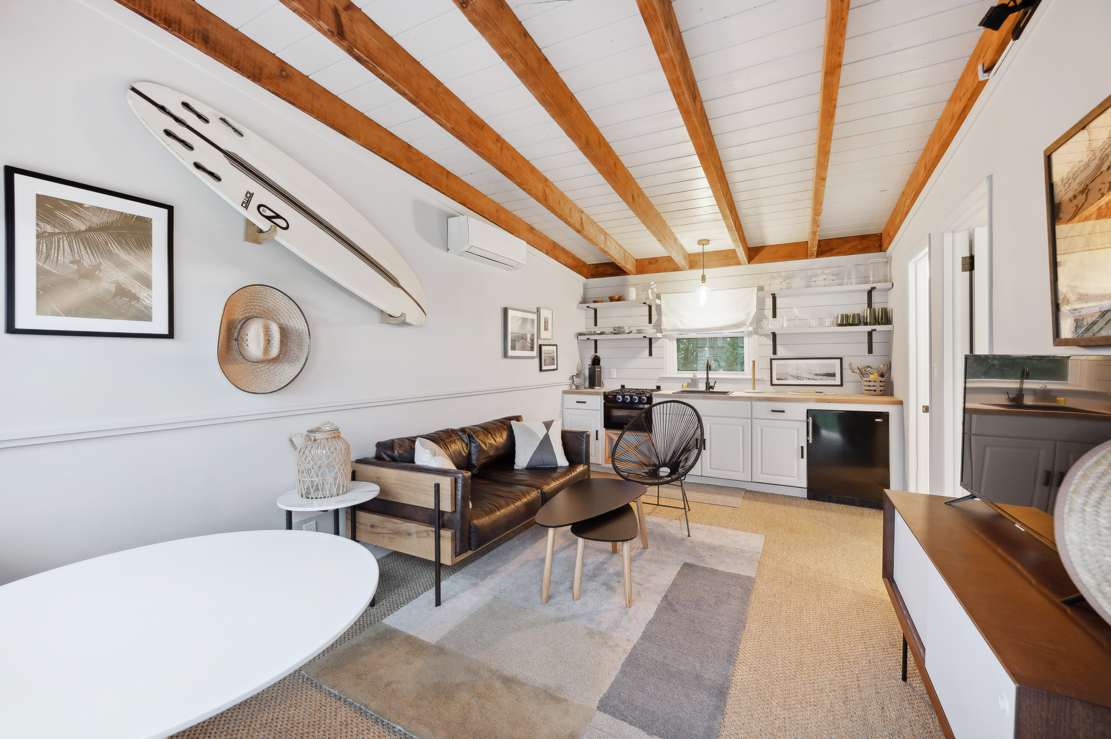 32 Lighthouse Road Hampton Bays, NY 11946 - Photo 42 of 51 a living room with furniture a clock on wall and a rug