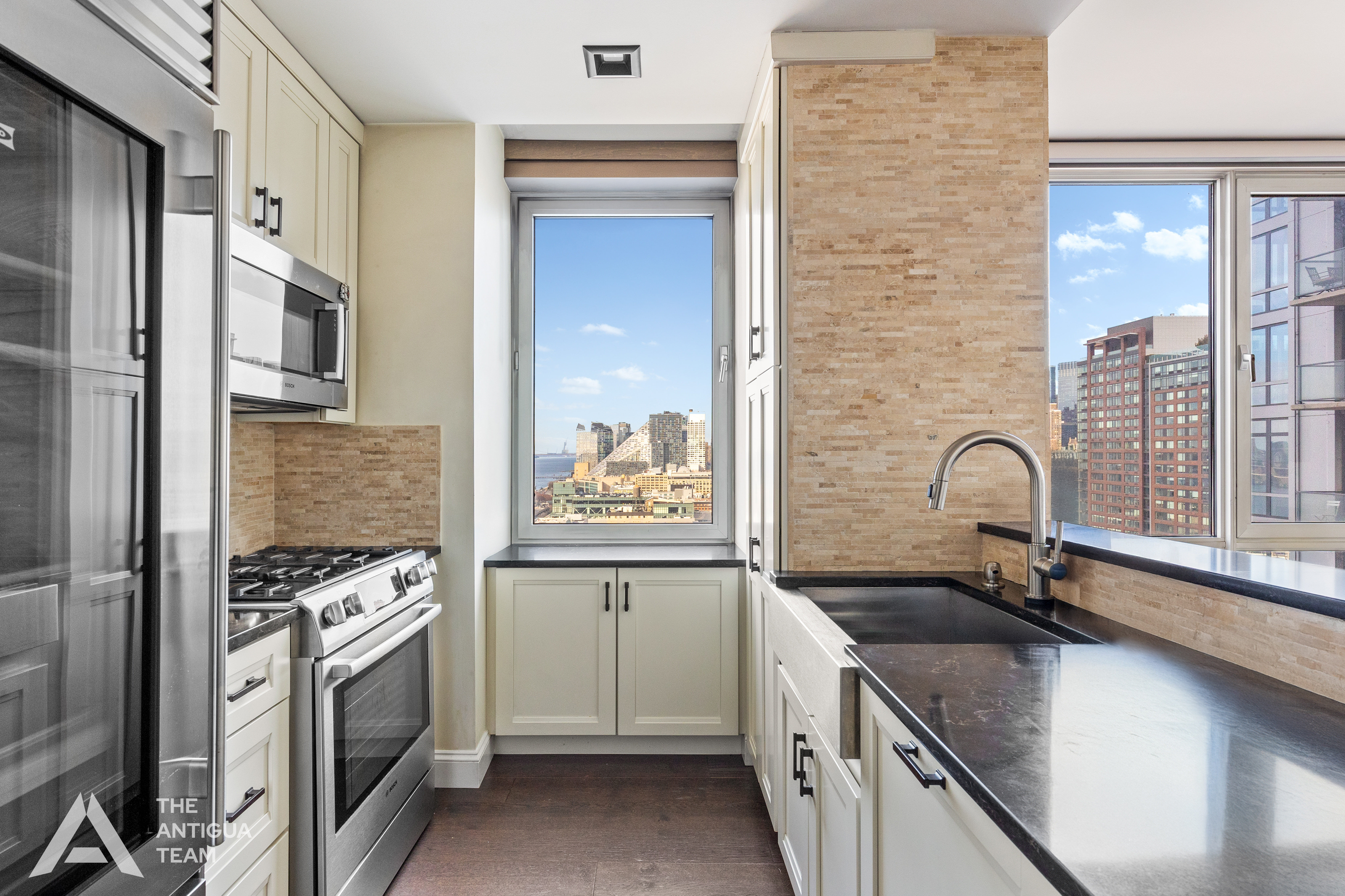 635 West 42nd Street, Unit 23E Manhattan, NY 10036 - Photo 3 of 16 a kitchen with stainless steel appliances granite countertop a sink stove and refrigerator