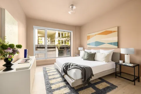 a bedroom with a large bed and a potted plant