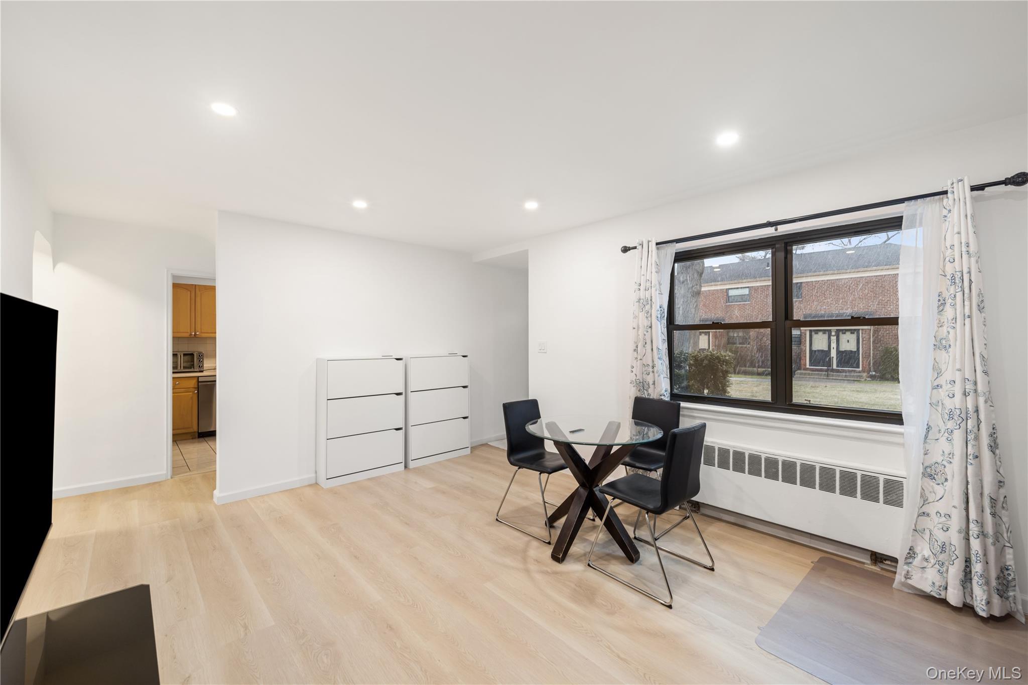 217-14 73rd Avenue, Unit 1 Queens, NY 11364 - Photo 7 of 19 a view of a room with wooden floor and windows