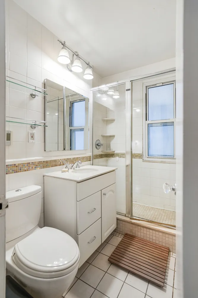 a bathroom with a granite countertop toilet sink and mirror