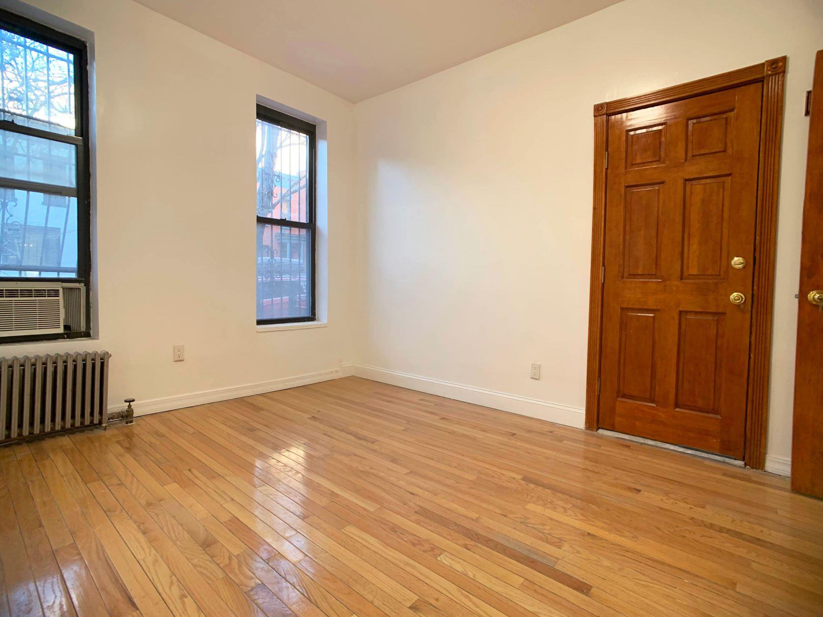630 President Street, Unit 1 Brooklyn, NY 11215 - Photo 5 of 11 an empty room with wooden floor and windows