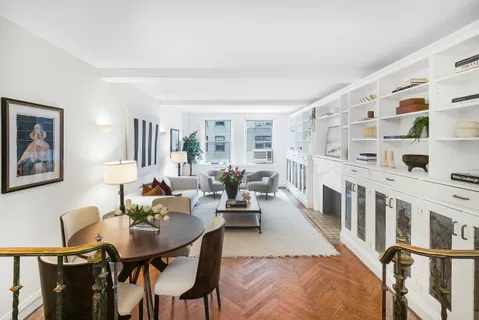 a living room with furniture kitchen view and a window