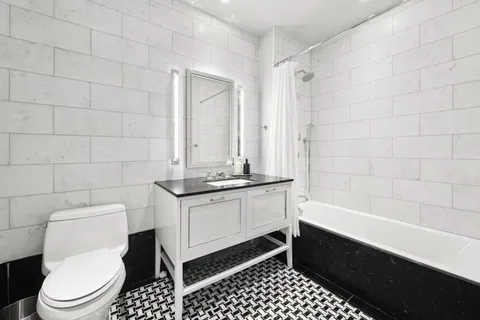 a bathroom with a granite countertop toilet a sink and a bathtub