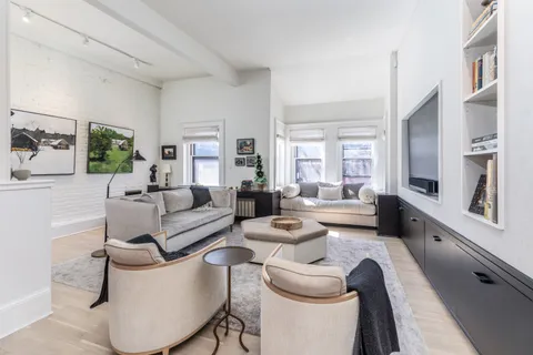 a living room with furniture a rug and a flat screen tv