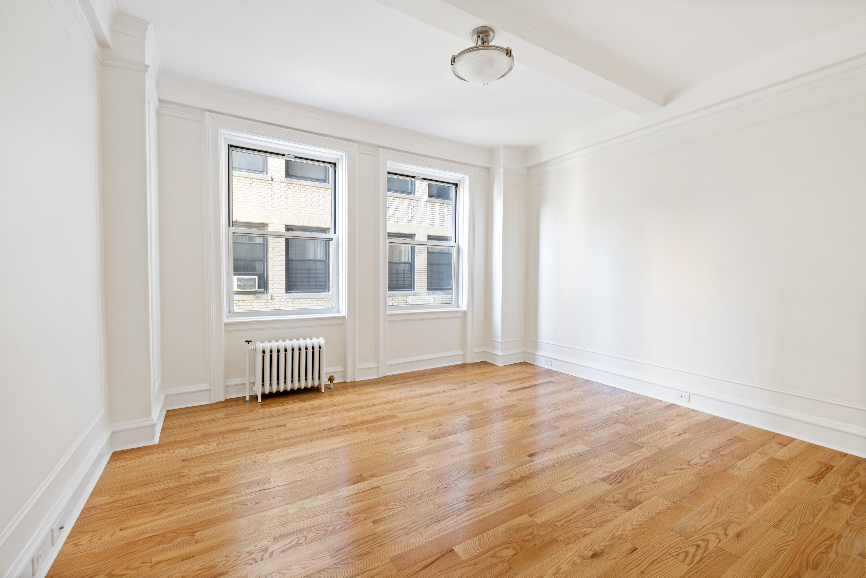 240 West 98th Street, Unit 7D Manhattan, NY 10025 - Photo 12 of 14 an empty room with wooden floor and windows