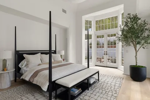 a bedroom with a bed and a large window