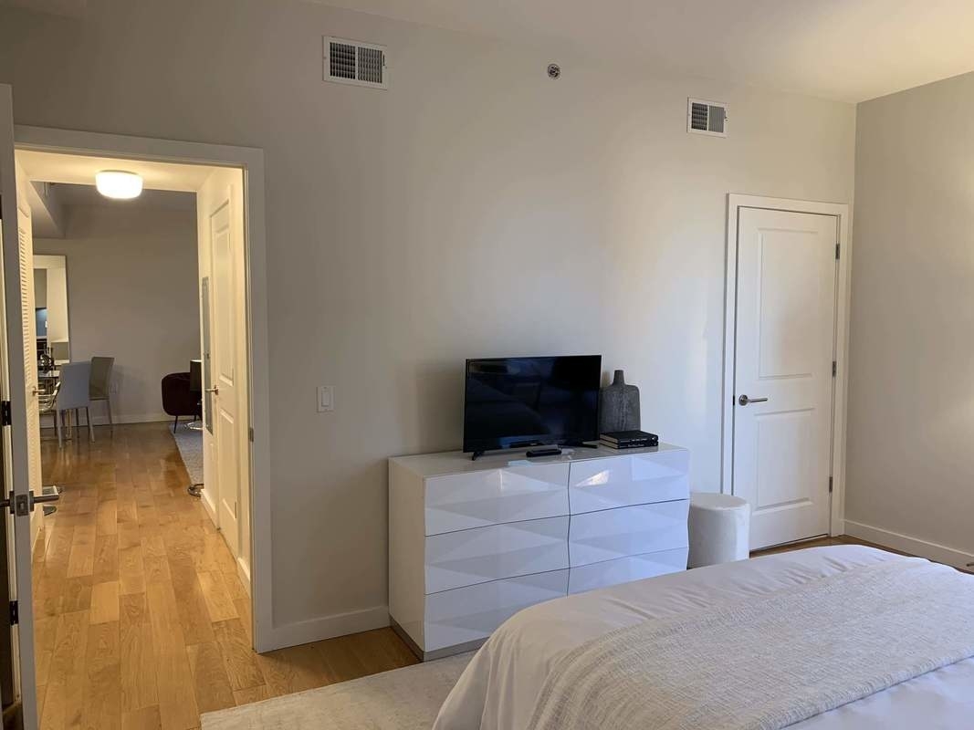 548 4th Avenue, Unit 4B Brooklyn, NY 11215 - Photo 15 of 22 a bedroom with a bed and a flat tv screen on dresser