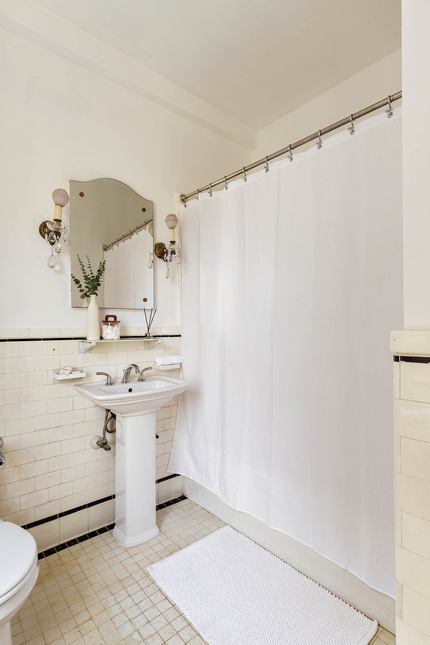 975 Park Avenue, Unit 10B Manhattan, NY 10028 - Photo 10 of 17 a bathroom with a sink a toilet and mirror