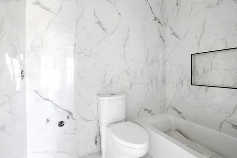 a white toilet sitting next to a bathroom sink