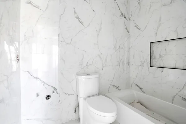 a white toilet sitting next to a bathroom sink