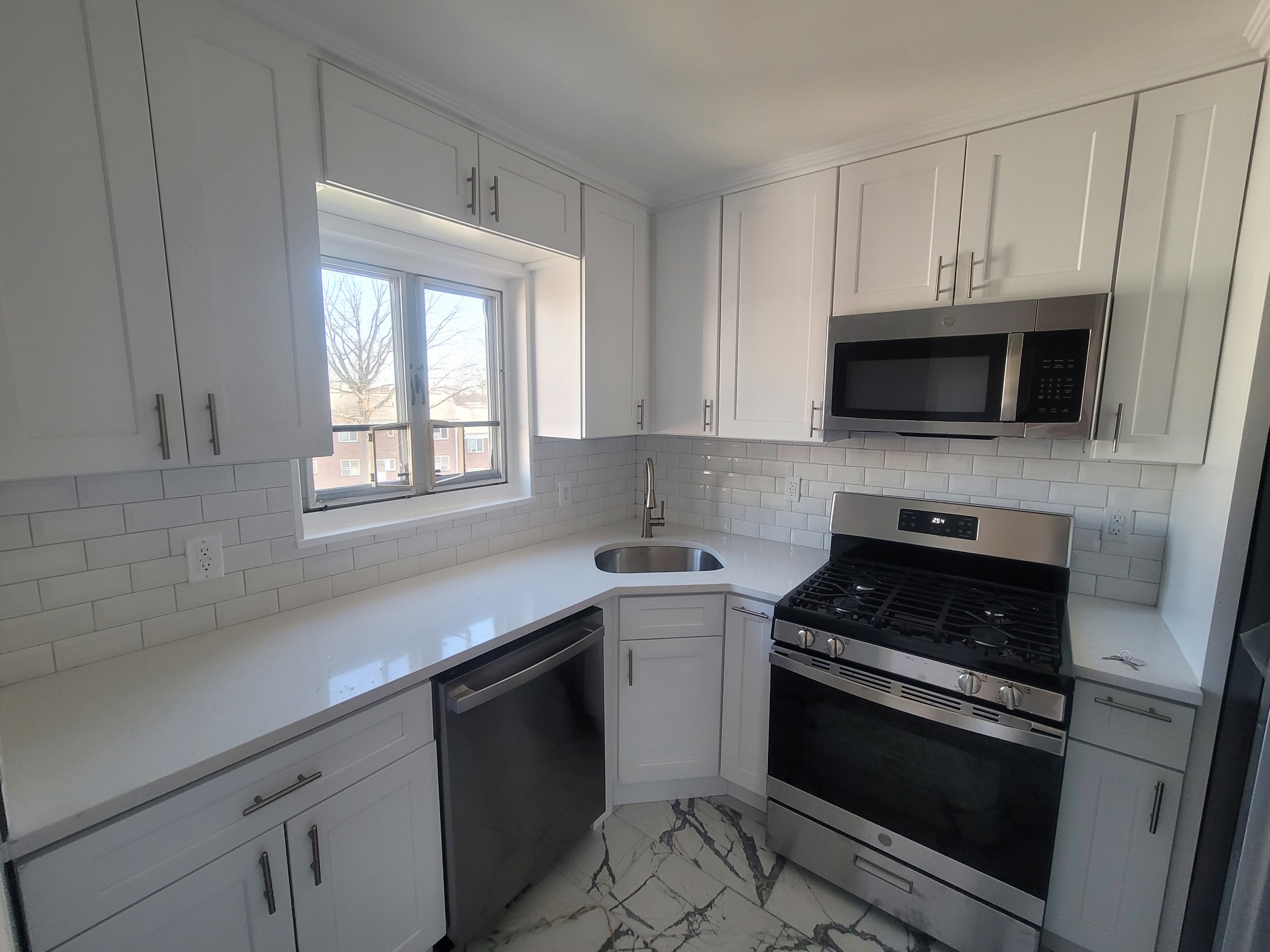 224-24 Manor Road, Unit U Queens, NY 11427 - Photo 4 of 10 a kitchen with cabinets stainless steel appliances and a window