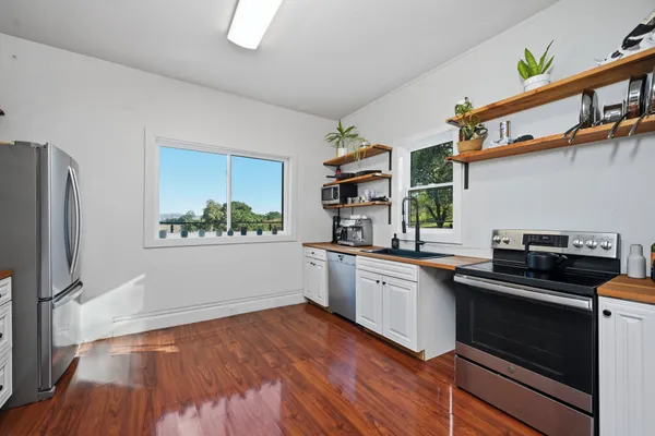 a large kitchen with cabinets wooden floor and stainless steel appliances