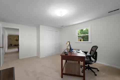 a view of a workspace with furniture and a window