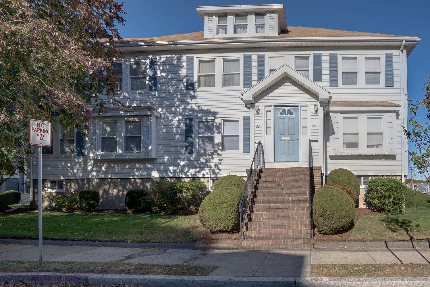 a view of a brick house with plants and large windows