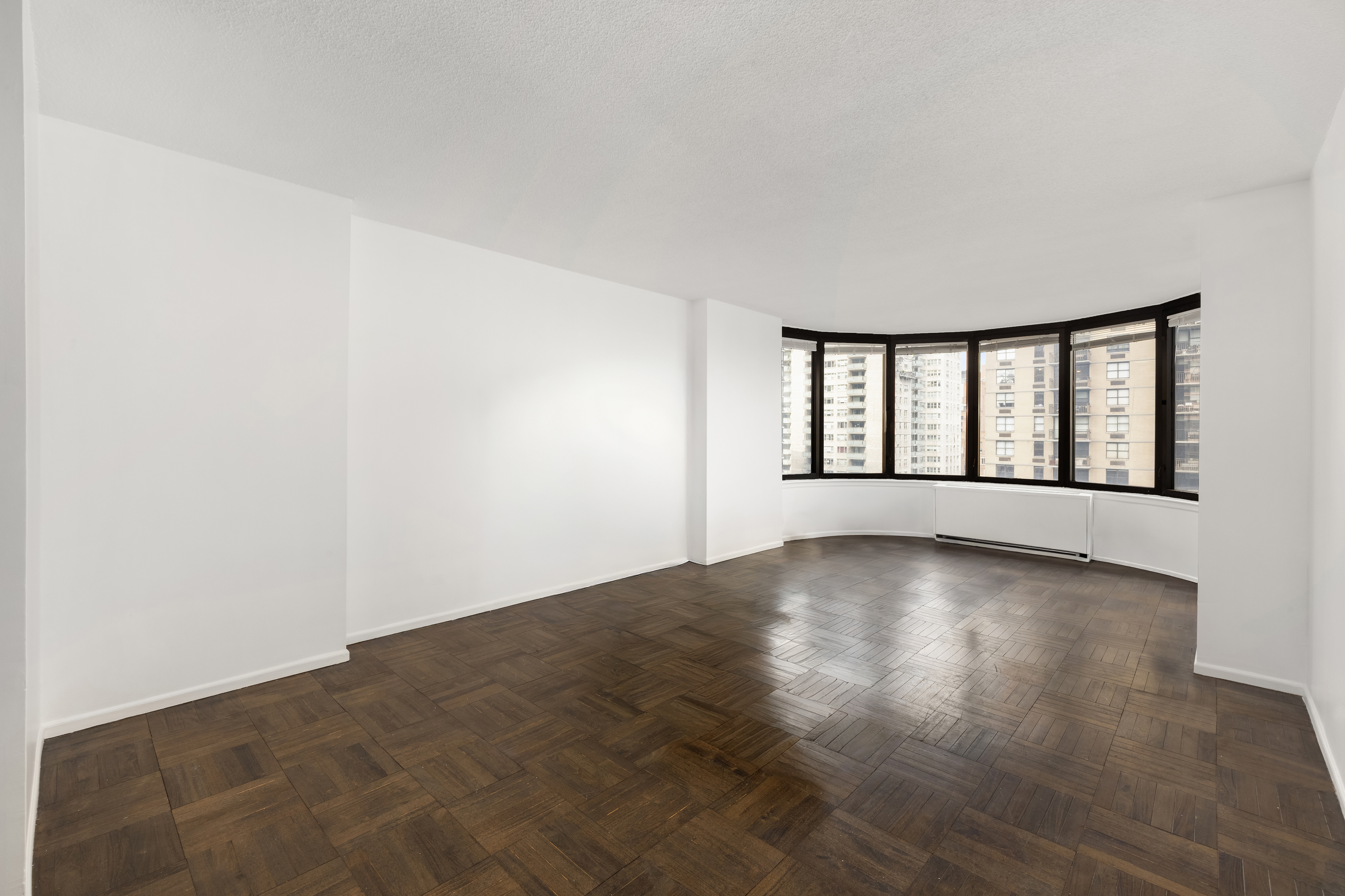 330 East 38th Street, Unit 22H Manhattan, NY 10016 - Photo 6 of 11 an empty room with wooden floor and windows
