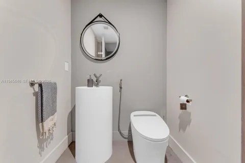 a white toilet sitting next to a bathroom sink