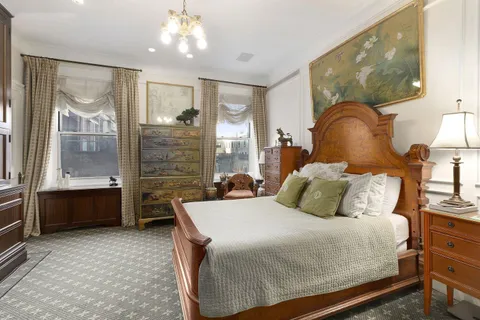 a bedroom with a large bed and a chandelier