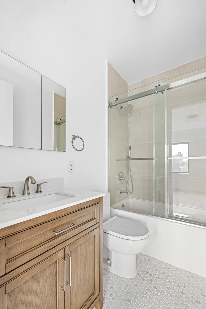 a bathroom with a sink a toilet and shower