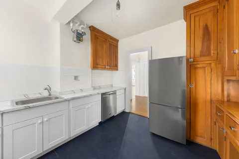 a kitchen with a refrigerator sink and cabinets