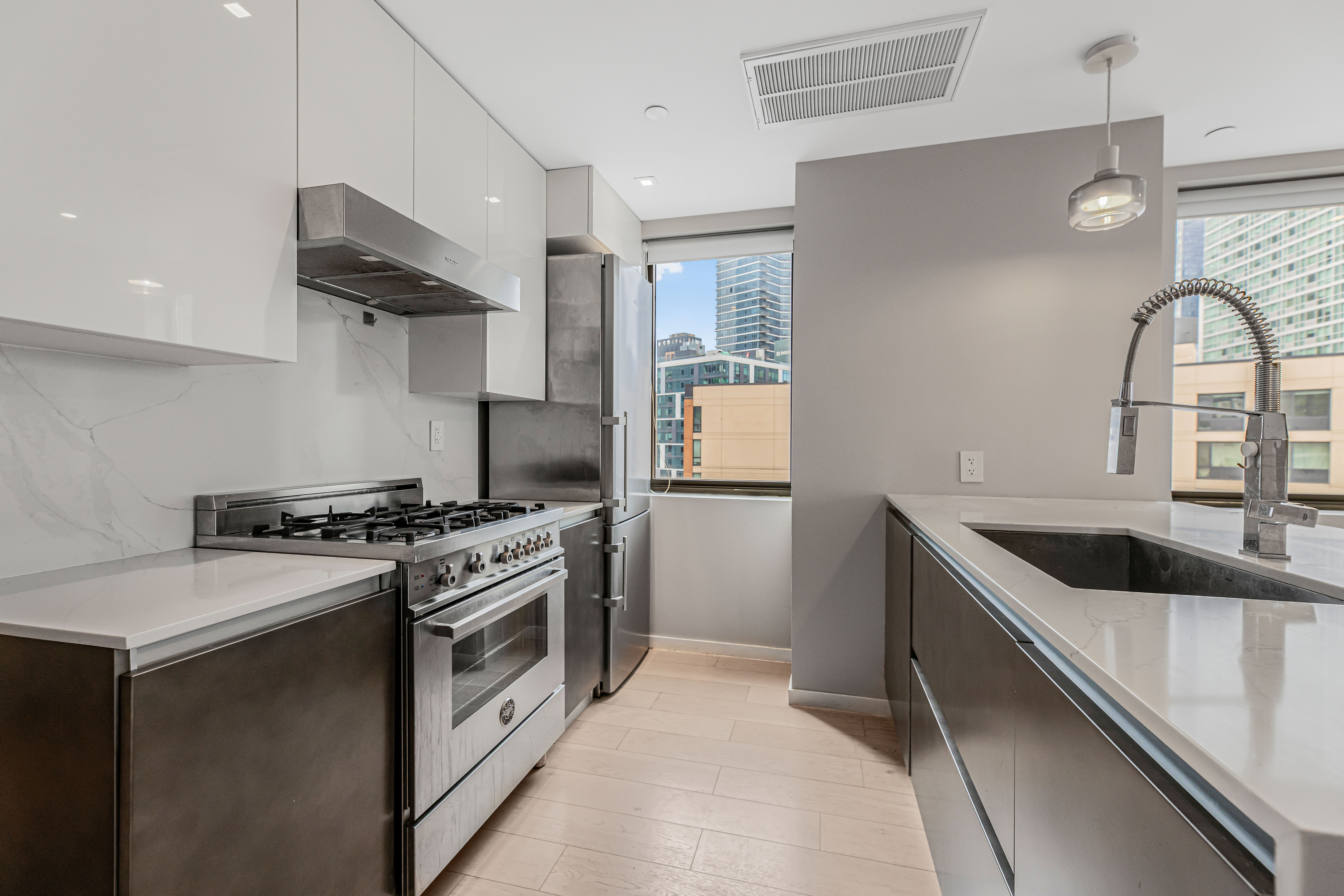 42-50 27th Street, Unit 9C Queens, NY 11101 - Photo 3 of 32 a kitchen with stainless steel appliances granite countertop a sink and a stove