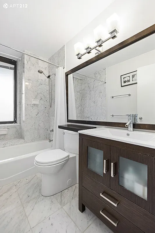 a bathroom with a sink mirror vanity and toilet