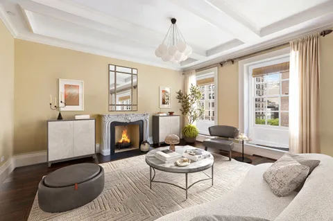 a living room with furniture a fireplace and a large window