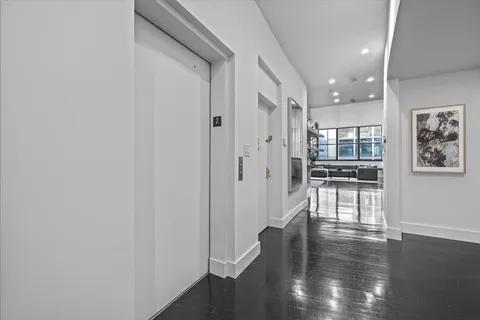 a view of a hallway with wooden floor and a cabinet